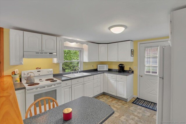124 Deepwood Dr, Hebron, CT 06231 - kitchen with white appliances, under cabinet range hood, dark countertops, a sink, and white cabinets
