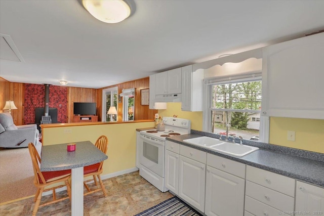 124 Deepwood Dr, Hebron, CT 06231 - kitchen featuring white range with electric stovetop, under cabinet range hood, a wood stove, open floor plan, and wooden walls