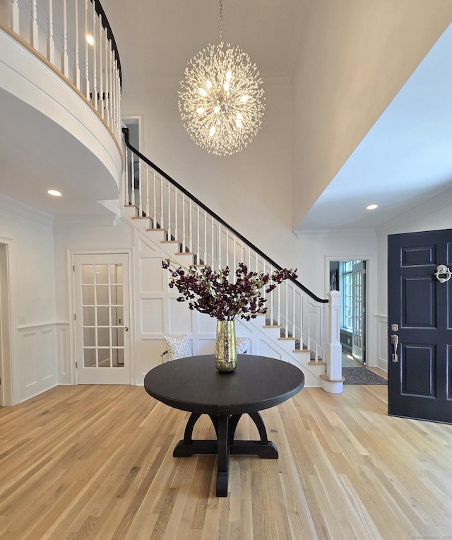 20 Crawford Rd, Westport, CT 06880 - foyer entrance with stairs, a decorative wall, wood finished floors, a high ceiling, and a chandelier