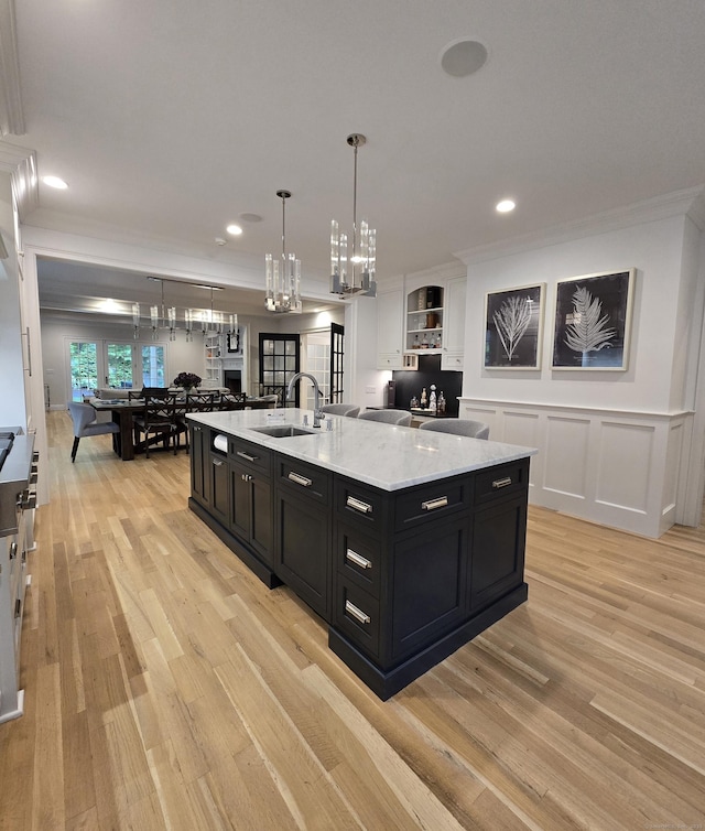 20 Crawford Rd, Westport, CT 06880 - kitchen with dark cabinets, a sink, a chandelier, ornamental molding, and light wood finished floors