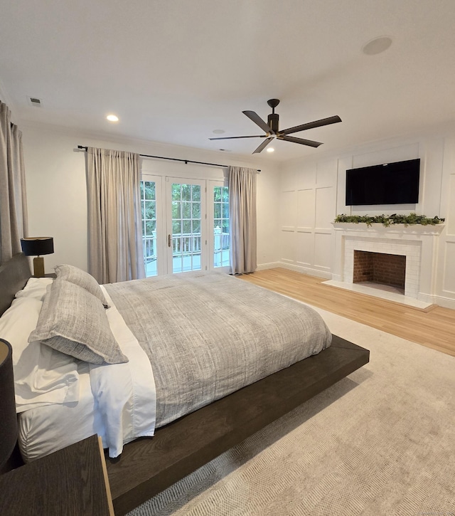 20 Crawford Rd, Westport, CT 06880 - bedroom with access to exterior, a fireplace with flush hearth, recessed lighting, ceiling fan, and wood finished floors