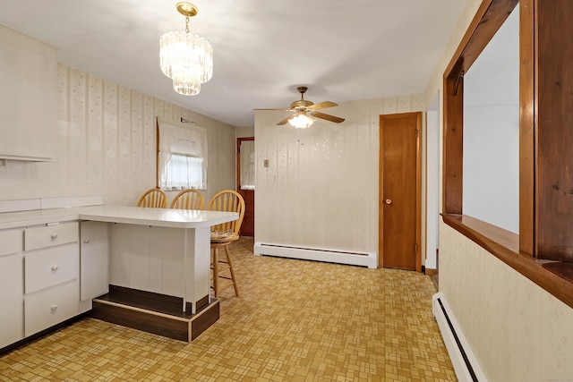 52 Fairview Ave, Bristol, CT 06010 - kitchen with a baseboard heating unit, wallpapered walls, ceiling fan, a peninsula, and light countertops
