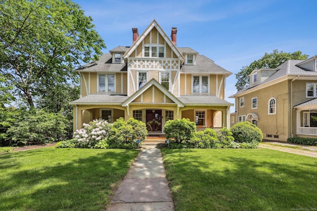 222 N Beacon St, Hartford, CT 06105 - tudor house with stucco siding, a chimney, covered porch, and a front yard