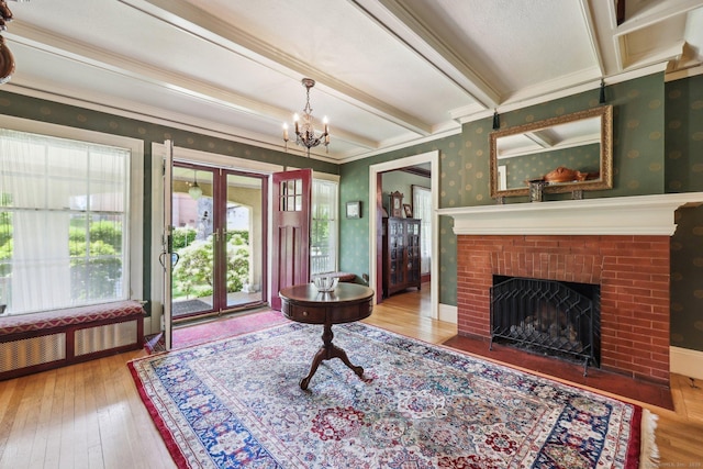 222 N Beacon St, Hartford, CT 06105 - living room with wood-type flooring, a brick fireplace, radiator heating unit, wallpapered walls, and a chandelier