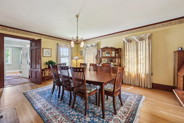 222 N Beacon St, Hartford, CT 06105 - dining space with a chandelier, plenty of natural light, light wood-style flooring, baseboards, and ornamental molding