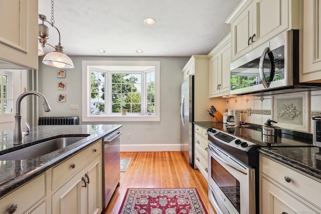 222 N Beacon St, Hartford, CT 06105 - kitchen with stainless steel appliances, a sink, baseboards, cream cabinets, and light wood-style flooring