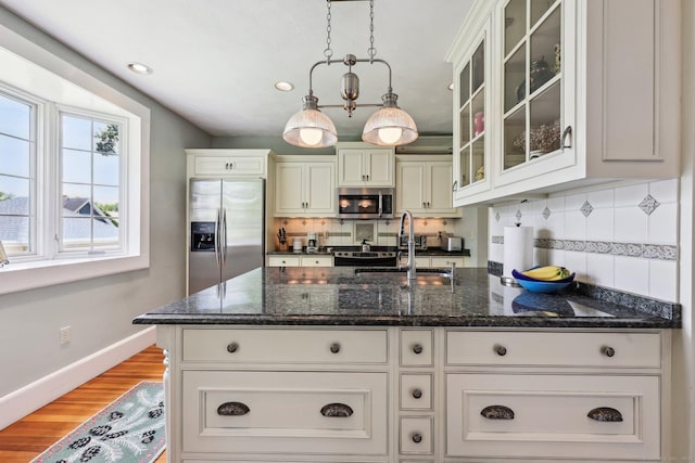 222 N Beacon St, Hartford, CT 06105 - kitchen with appliances with stainless steel finishes, baseboards, light wood-type flooring, backsplash, and glass insert cabinets