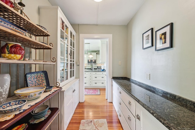 222 N Beacon St, Hartford, CT 06105 - kitchen featuring light wood finished floors, white cabinets, open shelves, and dark stone counters