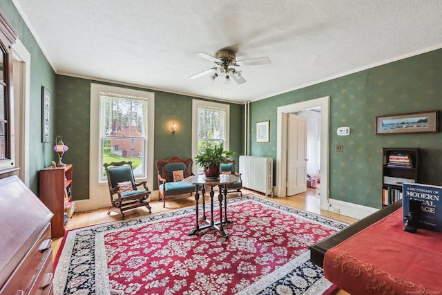 222 N Beacon St, Hartford, CT 06105 - living room with radiator heating unit, wood finished floors, crown molding, ceiling fan, and a textured ceiling