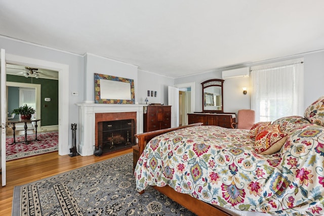 222 N Beacon St, Hartford, CT 06105 - bedroom with an AC wall unit, wood finished floors, a fireplace, and crown molding