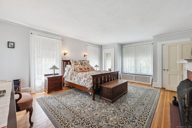 222 N Beacon St, Hartford, CT 06105 - bedroom featuring radiator, light wood-style flooring, a fireplace, and ornamental molding
