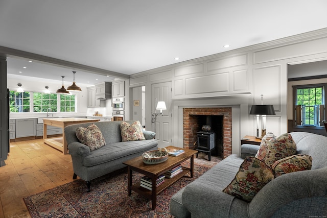 7 Shelter Rock Rd, East Haddam, CT 06423 - living room featuring ornamental molding, a decorative wall, a wood stove, light wood-style flooring, and recessed lighting