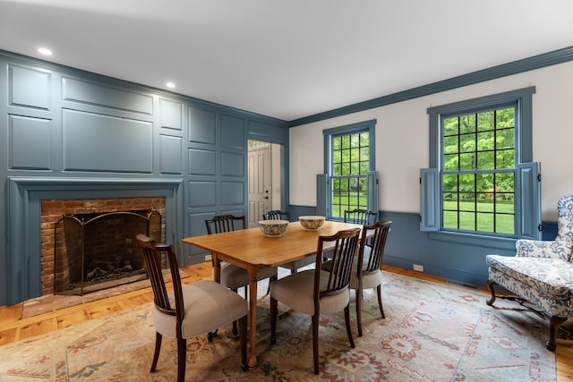 7 Shelter Rock Rd, East Haddam, CT 06423 - dining area featuring crown molding, light wood finished floors, a brick fireplace, a decorative wall, and a wainscoted wall