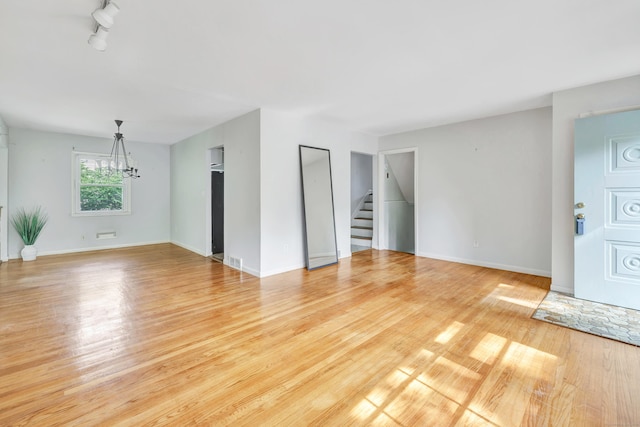 12 Sugar Plum Ln, Fairfield, CT 06824 - unfurnished living room featuring a chandelier, wood finished floors, stairs, and baseboards