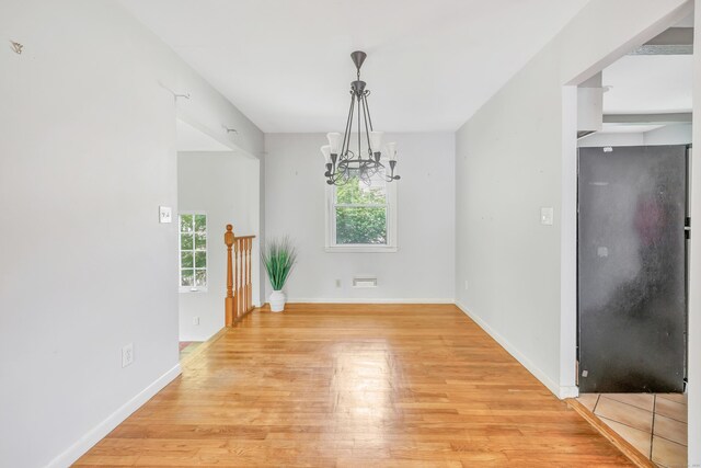 12 Sugar Plum Ln, Fairfield, CT 06824 - unfurnished dining area with a chandelier, light wood-type flooring, and baseboards