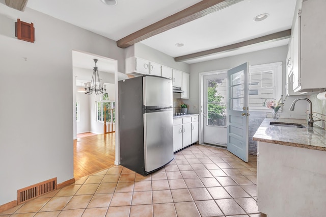12 Sugar Plum Ln, Fairfield, CT 06824 - kitchen featuring freestanding refrigerator, a sink, beamed ceiling, white cabinetry, and light tile patterned floors