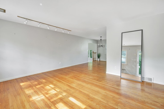 12 Sugar Plum Ln, Fairfield, CT 06824 - empty room with track lighting, a chandelier, light wood-type flooring, and baseboards