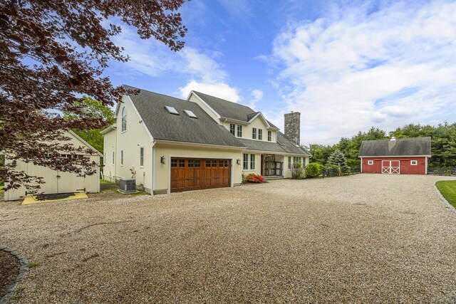 168 Fern Ave, Litchfield, CT 06759 - view of front of property featuring gravel driveway, a chimney, cooling unit, an attached garage, and an outdoor structure