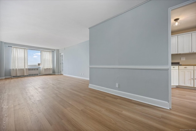 71 Strawberry Hill Ave Unit 710, Stamford, CT 06902 - unfurnished living room featuring radiator and light wood-style floors