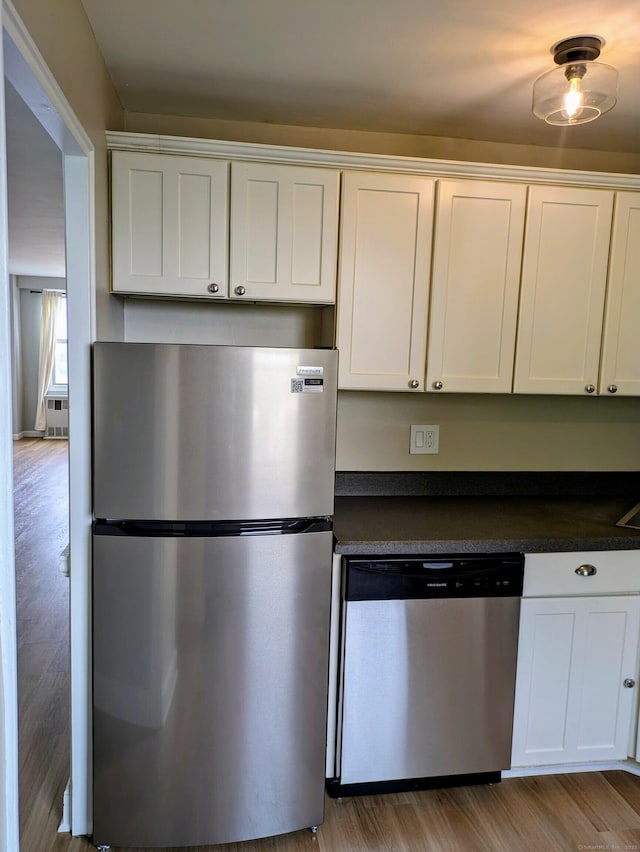 71 Strawberry Hill Ave Unit 710, Stamford, CT 06902 - kitchen with stainless steel appliances, dark countertops, white cabinetry, and wood finished floors