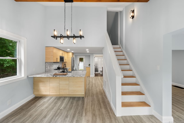 19 Old Acres Rd, East Haddam, CT 06469 - kitchen featuring light brown cabinetry, appliances with stainless steel finishes, a high ceiling, light wood-style flooring, and a chandelier