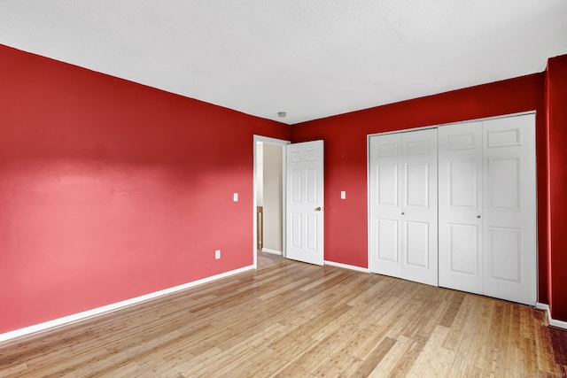 489 Wolcott St Apt 42, Bristol, CT 06010 - unfurnished bedroom featuring wood finished floors, baseboards, and a closet