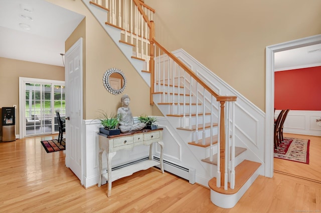 5 Jonathan Dr, Ellington, CT 06029 - stairs featuring wood finished floors, wainscoting, a baseboard heating unit, and a decorative wall