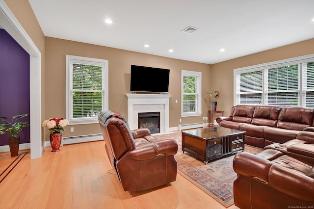 5 Jonathan Dr, Ellington, CT 06029 - living room with a baseboard radiator, light wood-type flooring, a glass covered fireplace, plenty of natural light, and recessed lighting