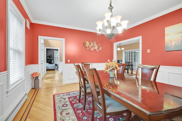 5 Jonathan Dr, Ellington, CT 06029 - dining area featuring baseboard heating, a chandelier, ornamental molding, wainscoting, and light wood-style floors