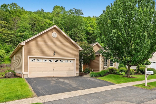 192 Rosewood Ln Unit 192, Berlin, CT 06037 - view of front of home with a garage, a front yard, stone siding, and a wooded view