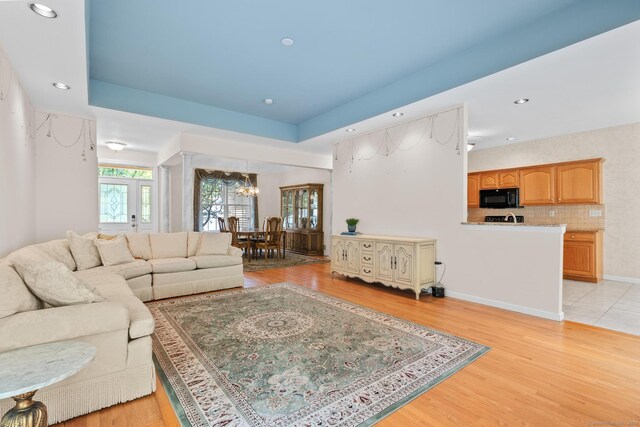 192 Rosewood Ln Unit 192, Berlin, CT 06037 - living room featuring a chandelier, light wood-style floors, a tray ceiling, recessed lighting, and baseboards