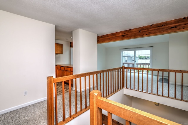 107 Ferry Ct Unit 107, Stratford, CT 06615 - hall featuring an upstairs landing, carpet, baseboards, and a textured ceiling
