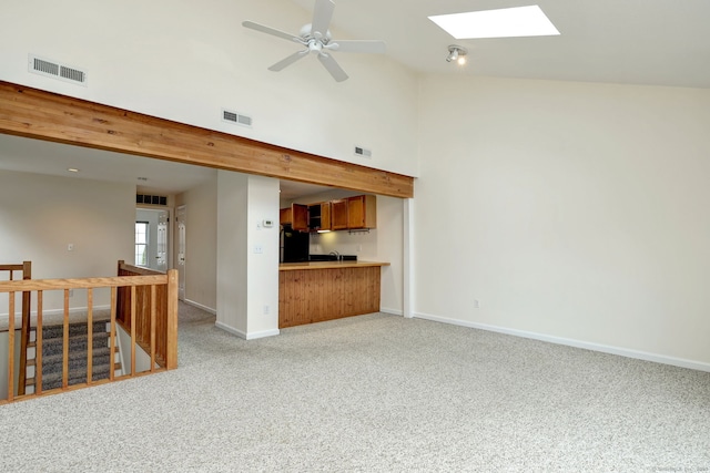 107 Ferry Ct Unit 107, Stratford, CT 06615 - unfurnished living room with a skylight, light colored carpet, baseboards, high vaulted ceiling, and ceiling fan