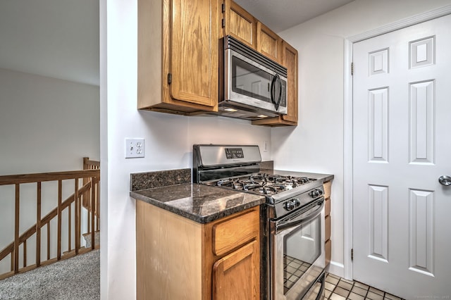 107 Ferry Ct Unit 107, Stratford, CT 06615 - kitchen featuring appliances with stainless steel finishes, brown cabinets, baseboards, and dark stone countertops