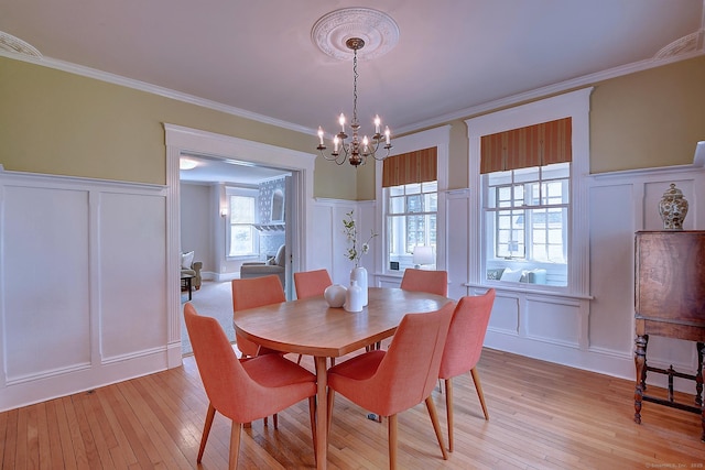 59 Golf St, Newington, CT 06111 - dining space featuring a decorative wall, a chandelier, light wood-style floors, crown molding, and wainscoting