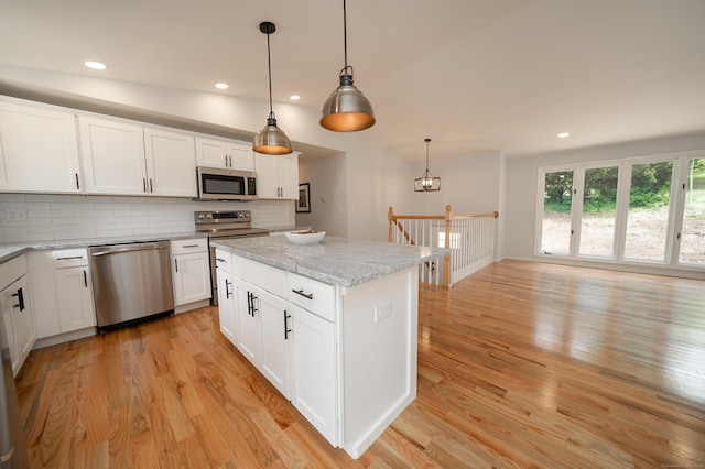 62 Wheeler Hill Dr, Durham, CT 06422 - kitchen with appliances with stainless steel finishes, light wood finished floors, tasteful backsplash, hanging light fixtures, and white cabinetry