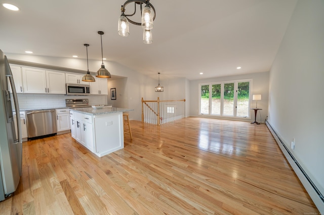 62 Wheeler Hill Dr, Durham, CT 06422 - kitchen with appliances with stainless steel finishes, a baseboard heating unit, white cabinetry, light wood-style flooring, and vaulted ceiling