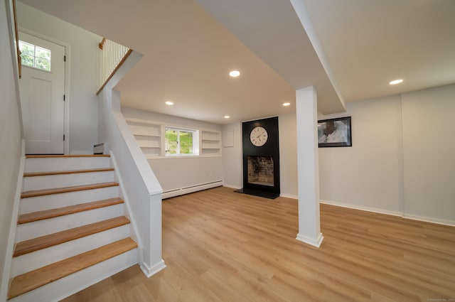 62 Wheeler Hill Dr, Durham, CT 06422 - basement with a baseboard radiator, light wood-type flooring, recessed lighting, stairs, and a fireplace with raised hearth