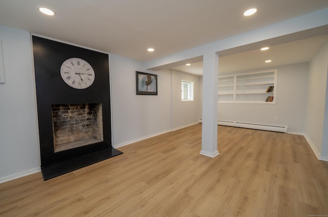 62 Wheeler Hill Dr, Durham, CT 06422 - below grade area with a baseboard heating unit, light wood-type flooring, recessed lighting, baseboards, and a fireplace with raised hearth