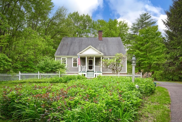 440 Mapleton Ave, Suffield, CT 06078 - view of front of home featuring a porch, a chimney, roof with shingles, and view of wooded area