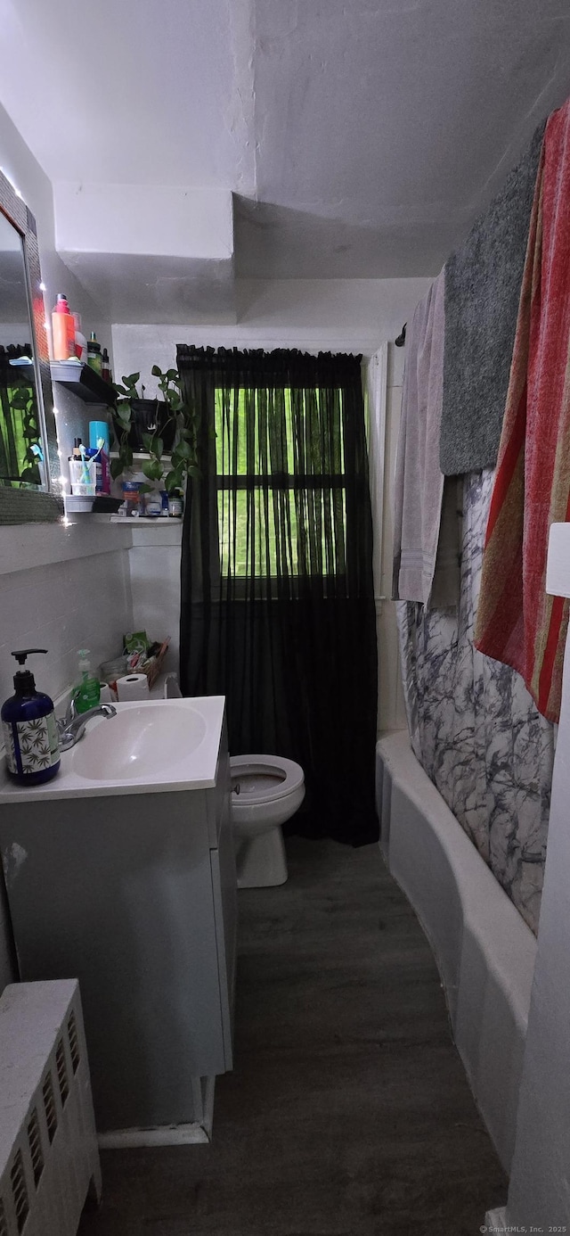 230 Winsted Rd, Torrington, CT 06790 - bathroom featuring vanity, wood finished floors, toilet, radiator heating unit, and shower / bath combo