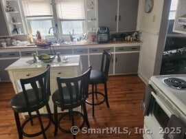 230 Winsted Rd, Torrington, CT 06790 - kitchen featuring dark wood-style flooring, white range with electric stovetop, gray cabinets, and light countertops