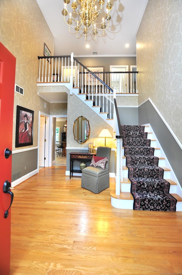 151 Oakridge, Farmington, CT 06085 - entrance foyer featuring wood finished floors, a chandelier, stairway, wallpapered walls, and a towering ceiling