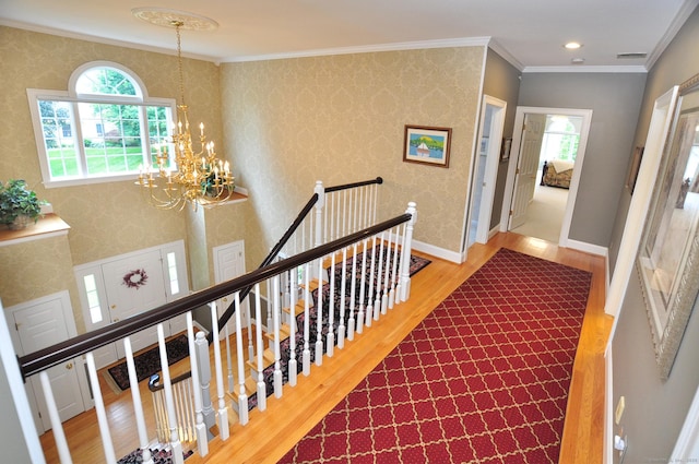 151 Oakridge, Farmington, CT 06085 - hall featuring wood finished floors, plenty of natural light, a chandelier, crown molding, and an upstairs landing