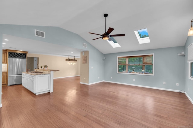 1190 Peck Ln, Cheshire, CT 06410 - unfurnished living room featuring lofted ceiling, a skylight, light wood-style flooring, a ceiling fan, and baseboards