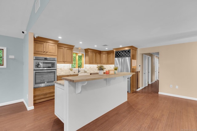 1190 Peck Ln, Cheshire, CT 06410 - kitchen with stainless steel appliances, light countertops, baseboards, wood finished floors, and recessed lighting