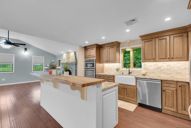 1190 Peck Ln, Cheshire, CT 06410 - kitchen with appliances with stainless steel finishes, a sink, ceiling fan, a kitchen breakfast bar, and backsplash
