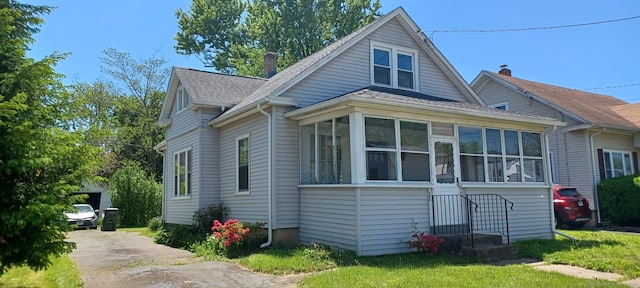 25 Richard Rd, East Hartford, CT 06108 - view of property exterior featuring roof with shingles, a chimney, and a sunroom