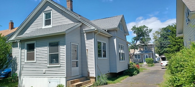 25 Richard Rd, East Hartford, CT 06108 - view of home's exterior with entry steps, a chimney, and roof with shingles