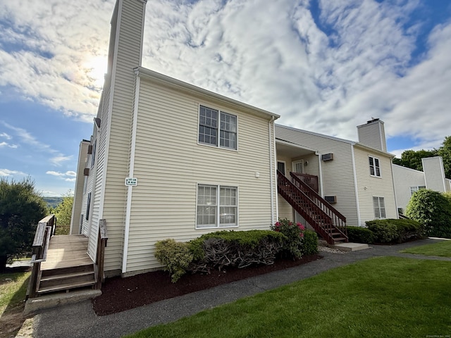 102 Beard Dr Unit 102, New Milford, CT 06776 - view of front of house featuring a chimney, stairs, a front lawn, and a deck